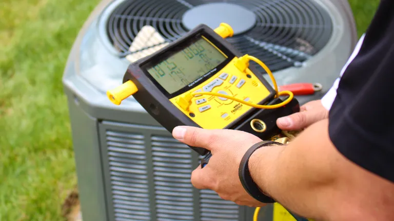 tech performing hvac maintenance on an ac unit
